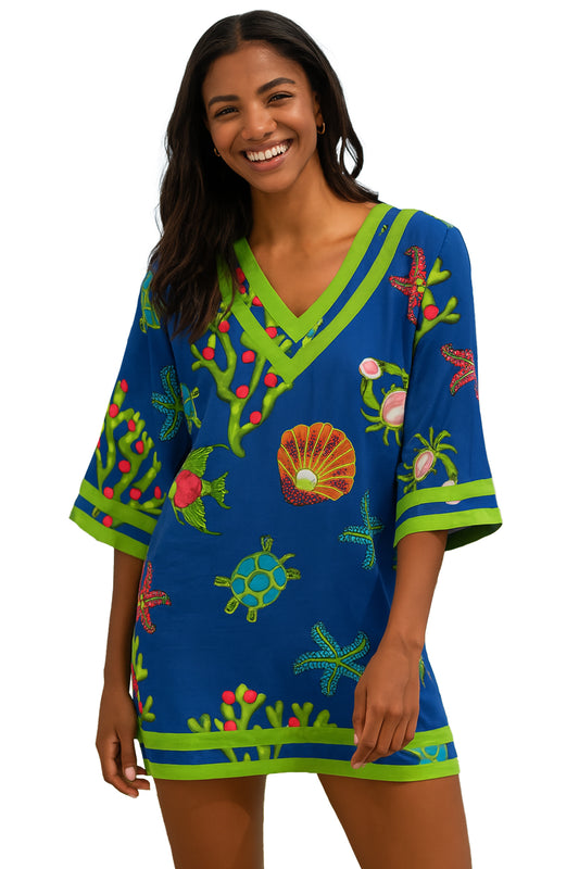 Woman wearing a colorful tropical-themed dress with a white background