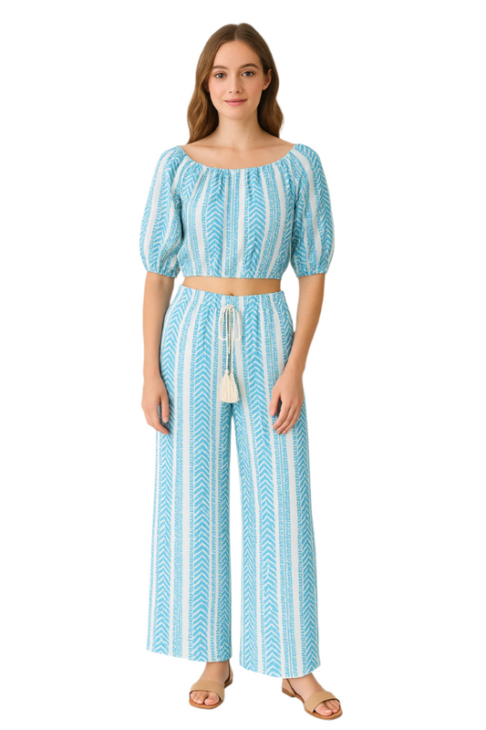 Woman wearing a blue and white patterned outfit on a white background